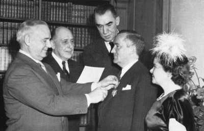 A black and white photograph of Donovan presenting Stephenson with a medal.